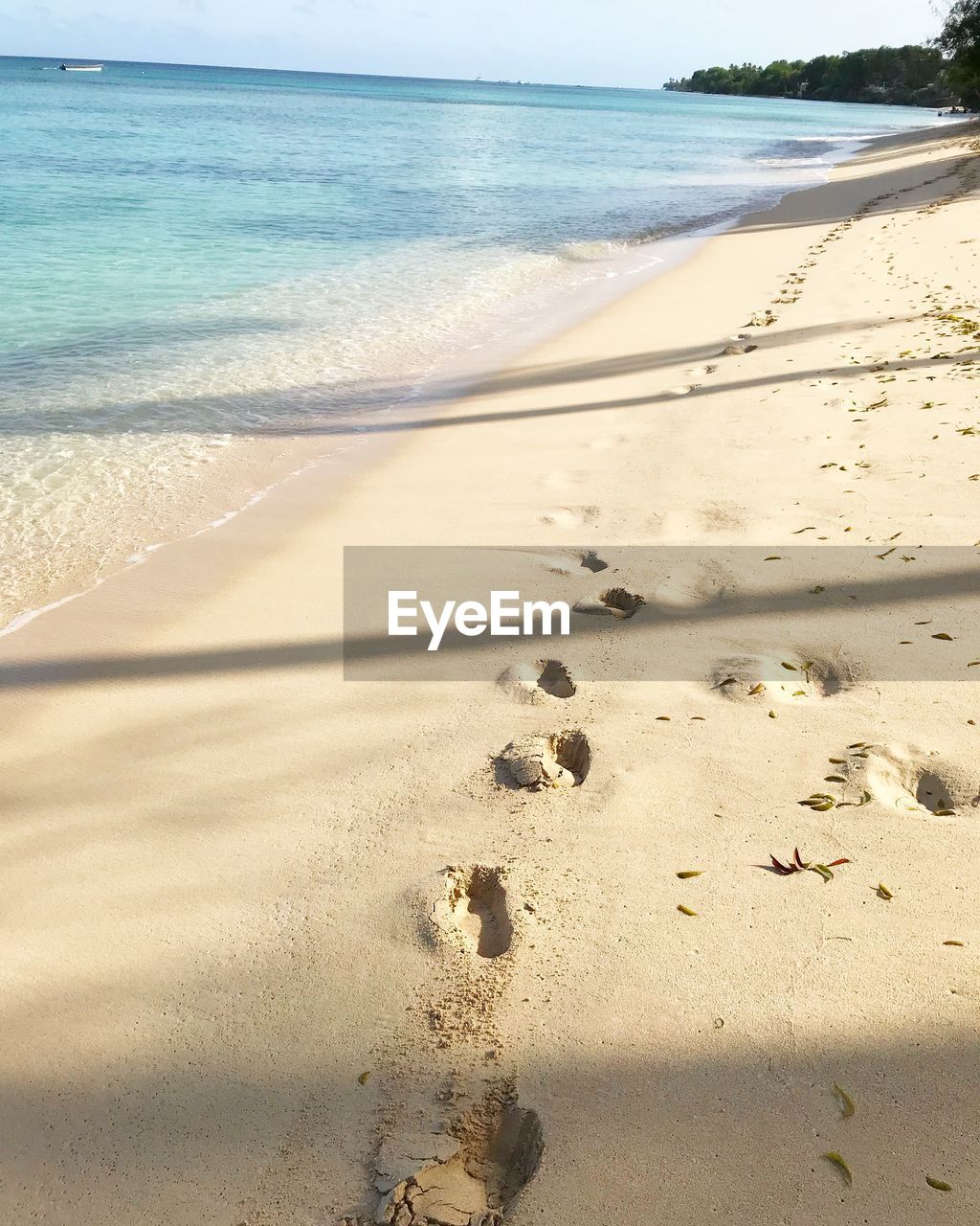 Footprints on sand at beach against sky