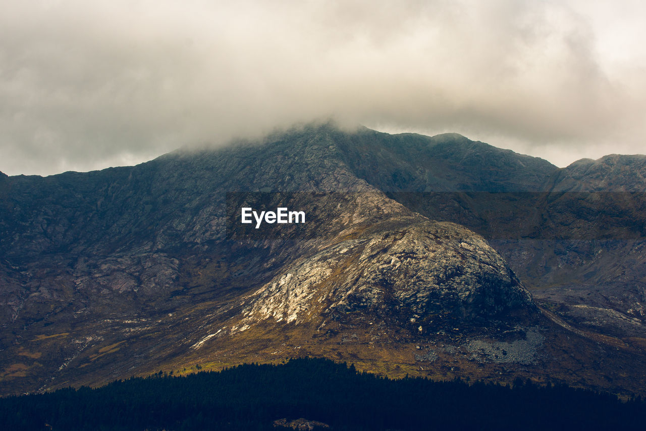 Scenic view of mountains against cloudy sky