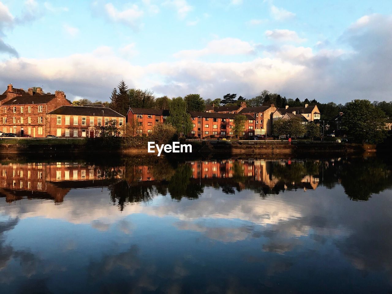 Reflection of buildings on lake against sky