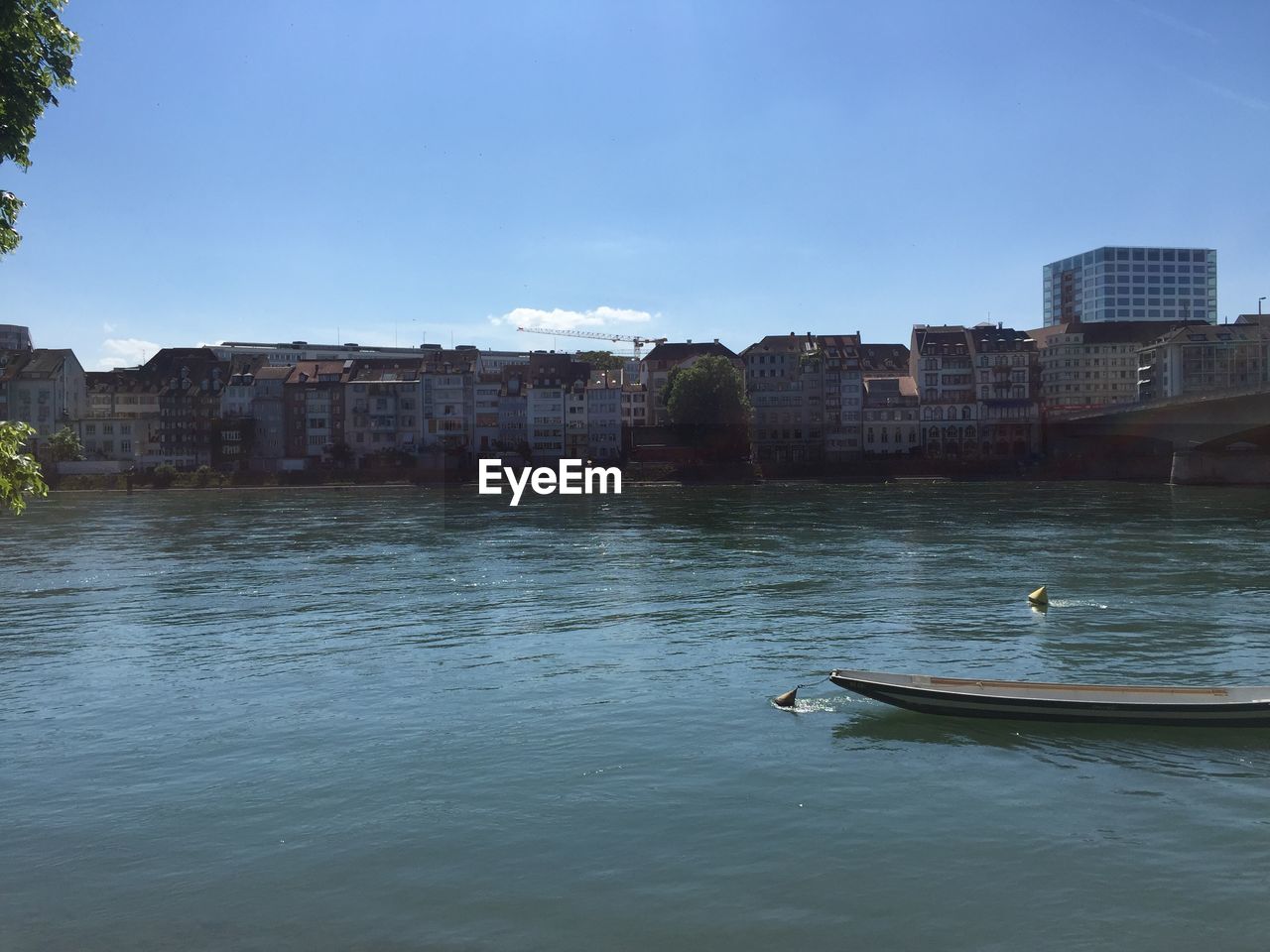 Buildings by river against sky in city