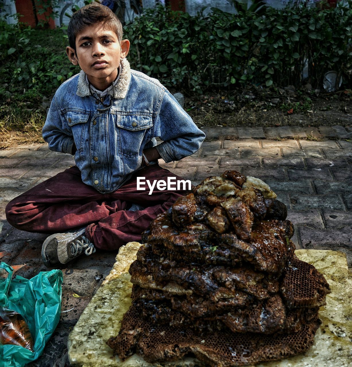 Portrait of teenage boy selling honey on street