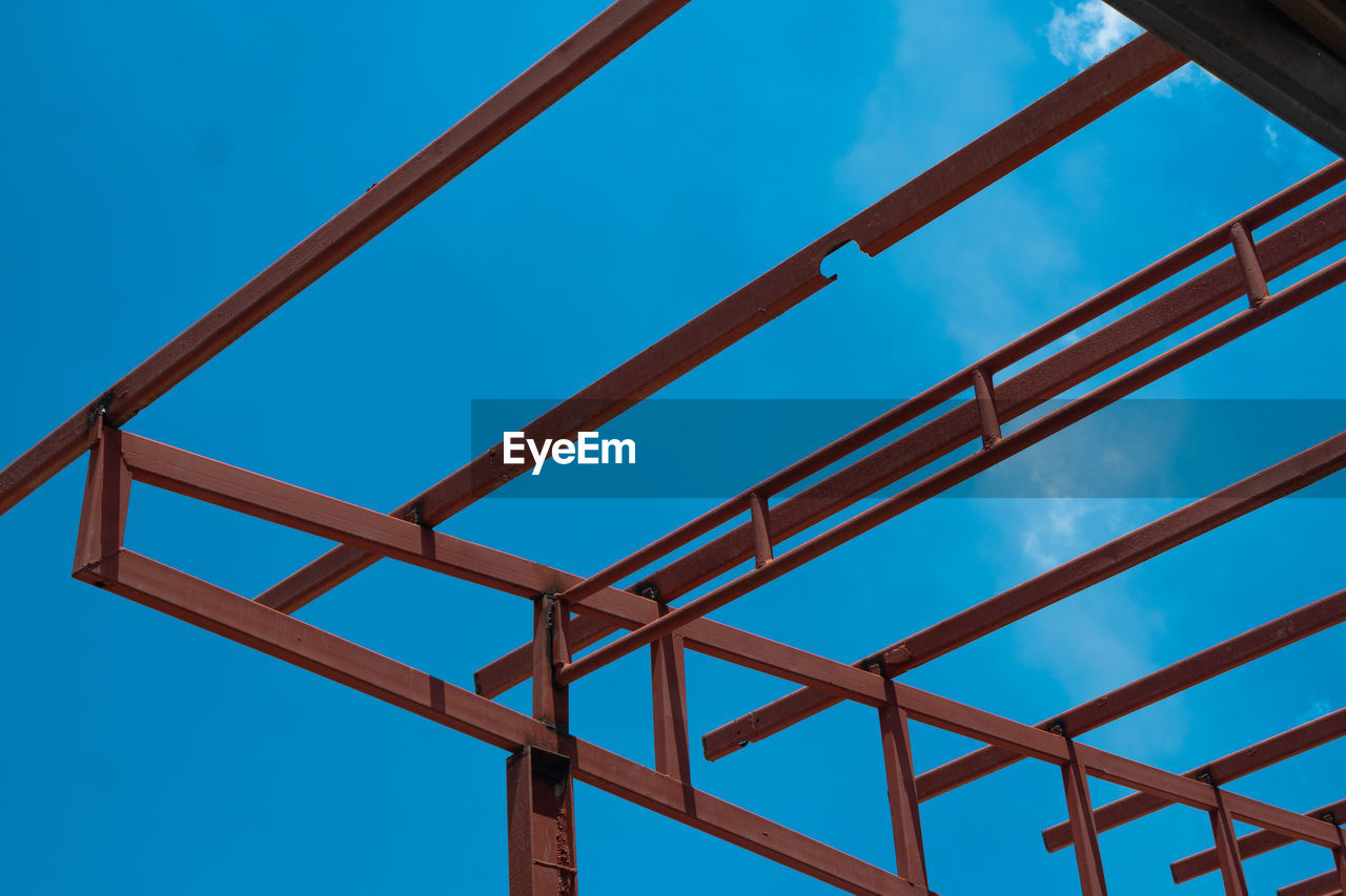 Low angle view of metallic structure against blue sky