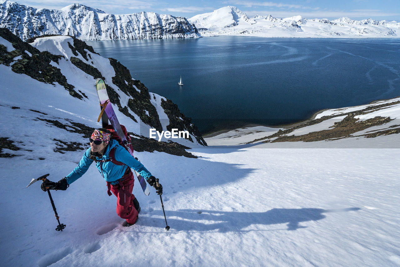 Woman skinning up mountain to ski in svalbard
