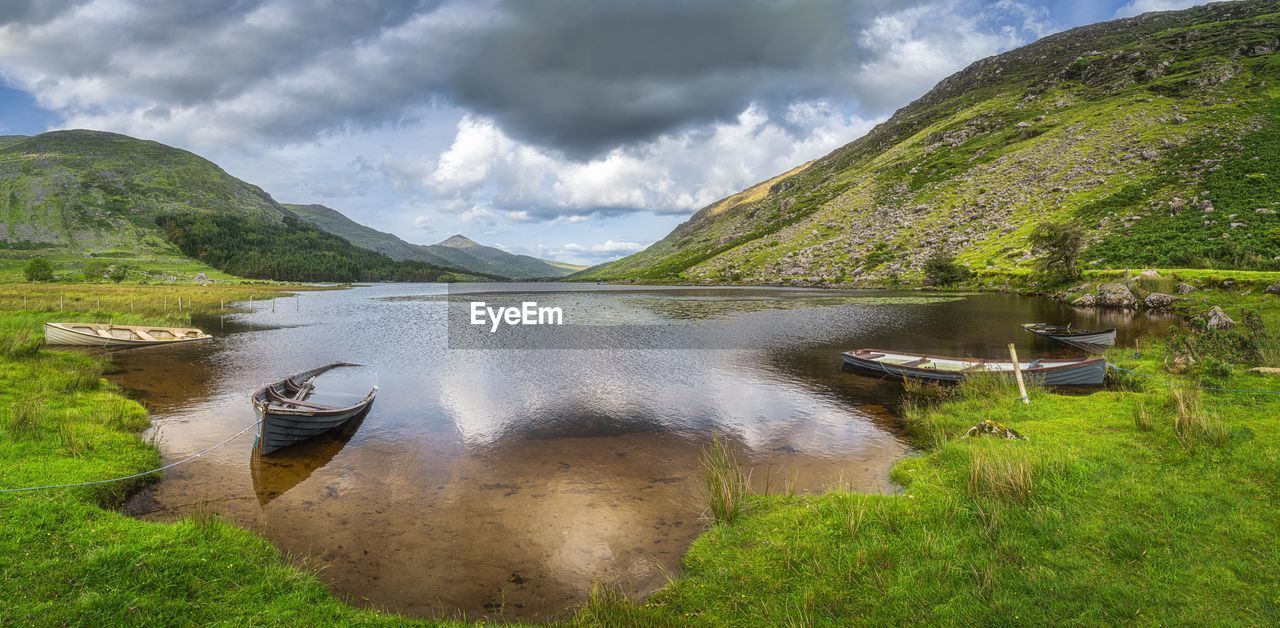 Sunken and submerged paddle boats in lough gummeenduff with view on beautiful black valley, ireland