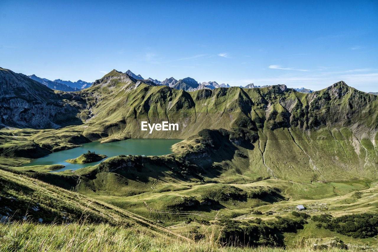 environment, landscape, scenics - nature, wilderness, mountain, nature, beauty in nature, sky, mountain range, land, plant, no people, non-urban scene, tranquility, tranquil scene, travel destinations, travel, plateau, ridge, blue, mountain pass, grass, valley, outdoors, day, green, water, cloud, rock, clear sky, tree, idyllic, activity, tourism, national park, coniferous tree, sunlight, pinaceae