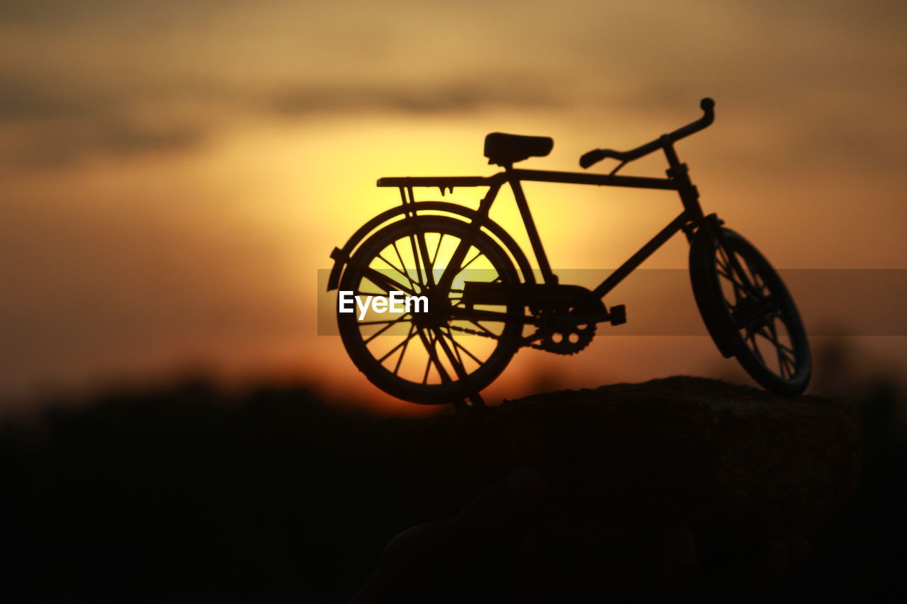 Close-up of silhouette bicycle against sky during sunset