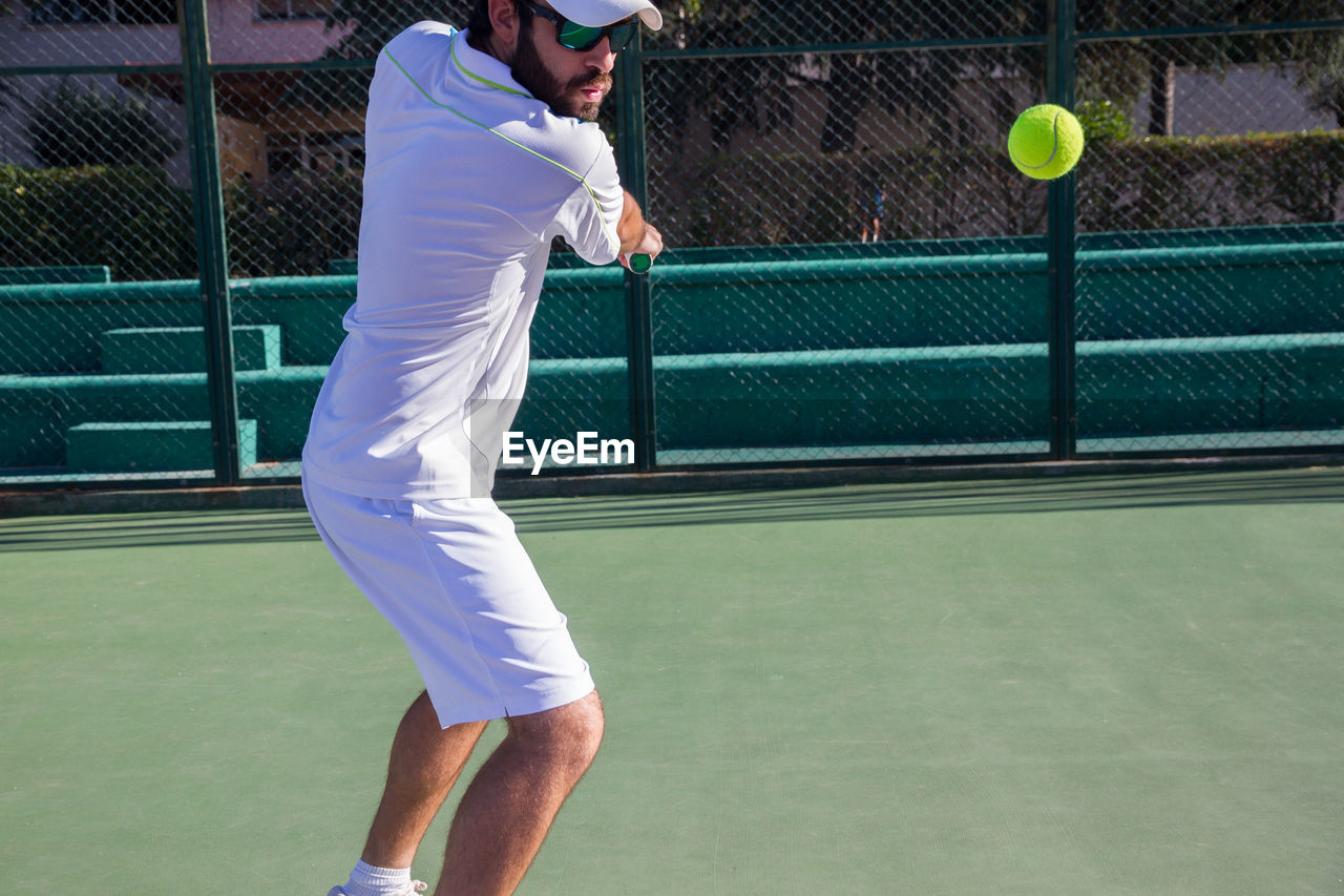 Man playing tennis on court