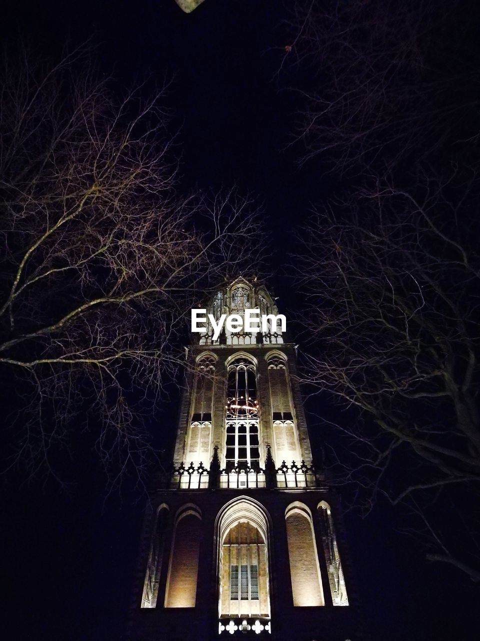 LOW ANGLE VIEW OF ILLUMINATED BUILDING AGAINST CLEAR SKY AT NIGHT