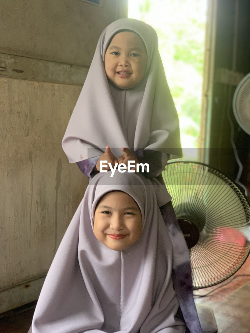 female, hijab, women, adult, smiling, portrait, two people, happiness, child, clothing, headscarf, robe, togetherness, lifestyles, traditional clothing, childhood, looking at camera, indoors, veil, emotion, relaxation, young adult, person, front view, religion, family, bathrobe, positive emotion, cheerful, sitting, body care, parent