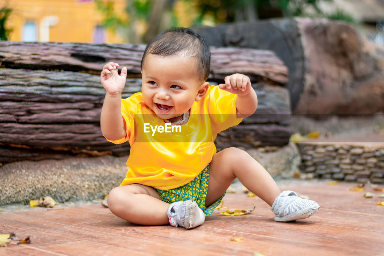Portrait of the cute boy sitting on the floor