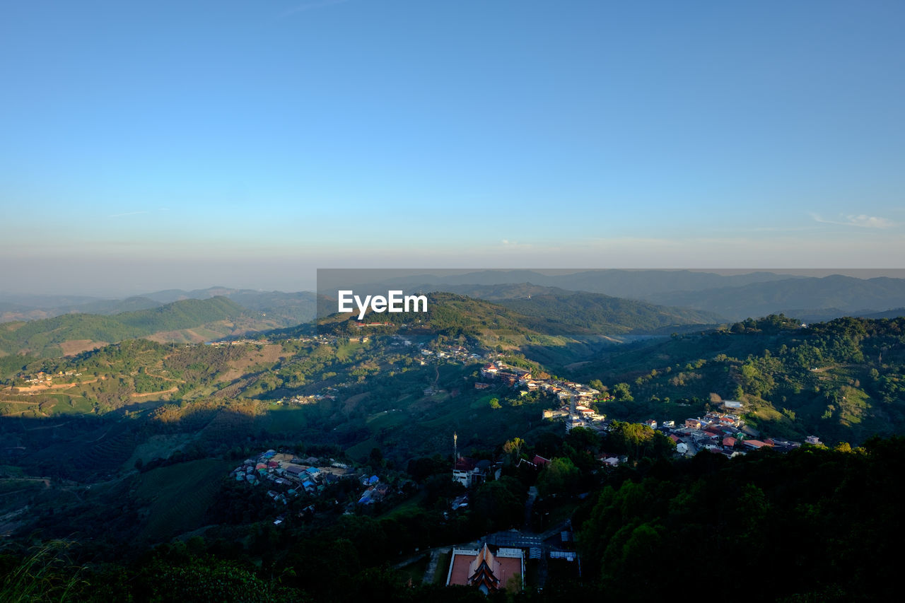 AERIAL VIEW OF TOWNSCAPE AGAINST MOUNTAIN