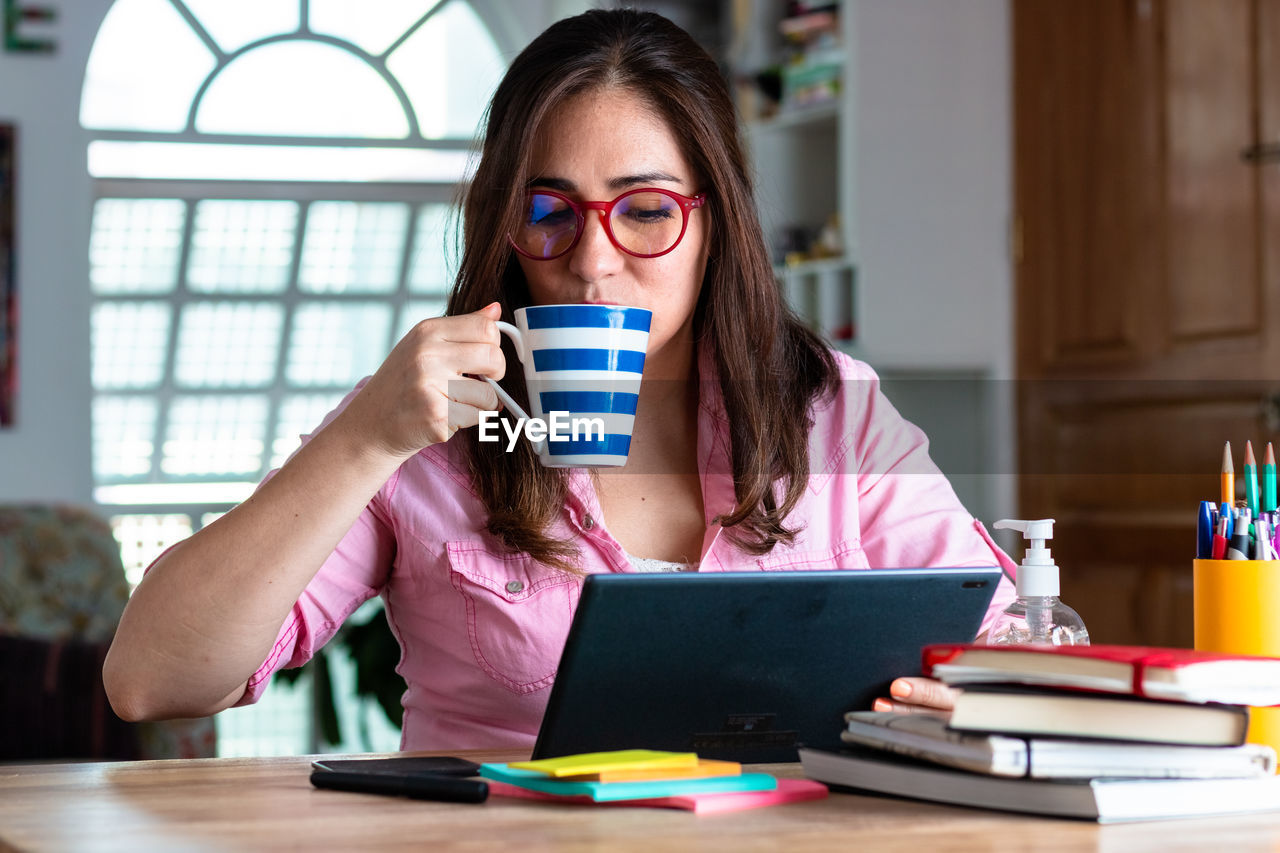 PORTRAIT OF WOMAN WITH COFFEE CUP