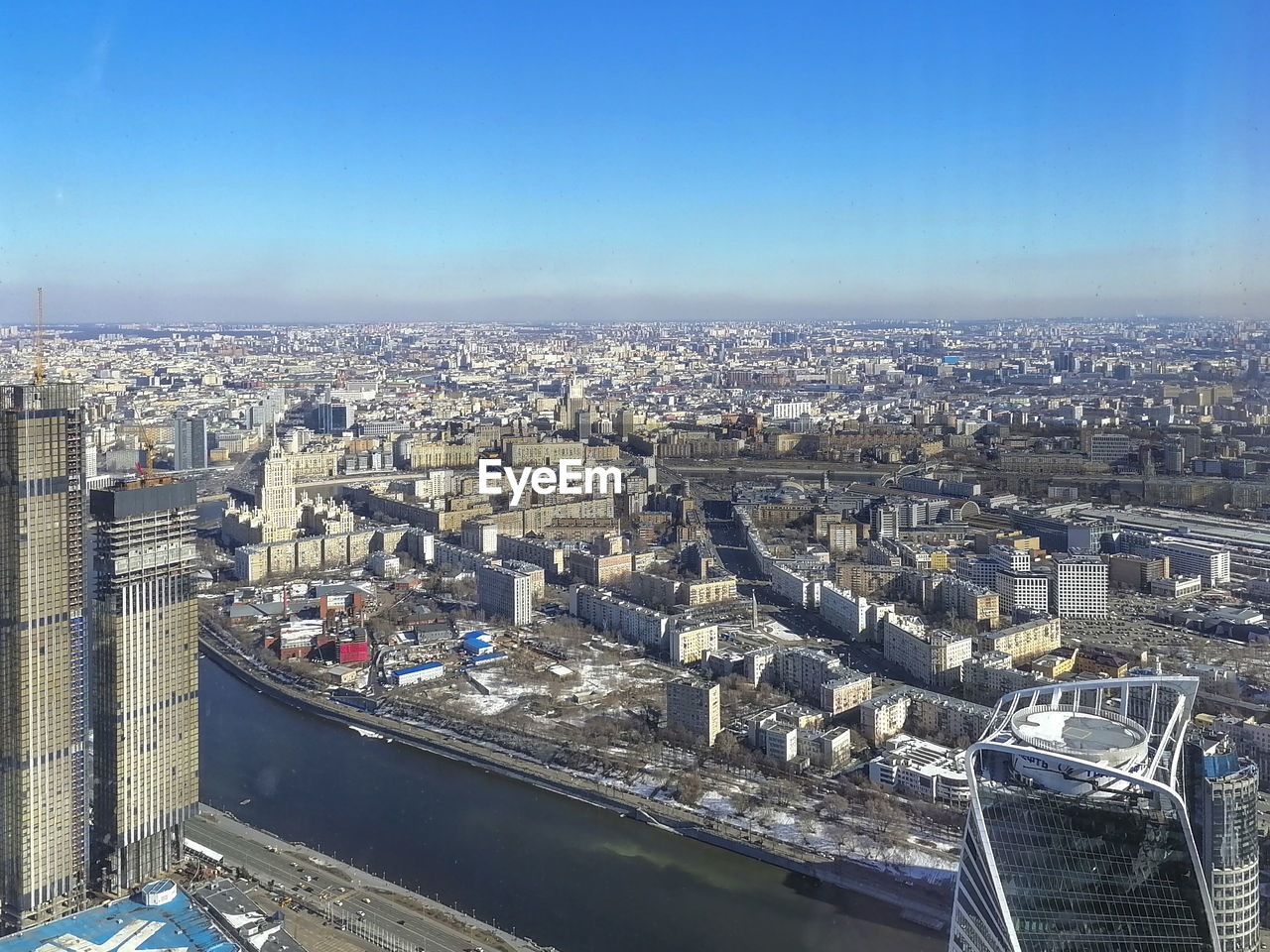 HIGH ANGLE VIEW OF BUILDINGS IN CITY AGAINST BLUE SKY