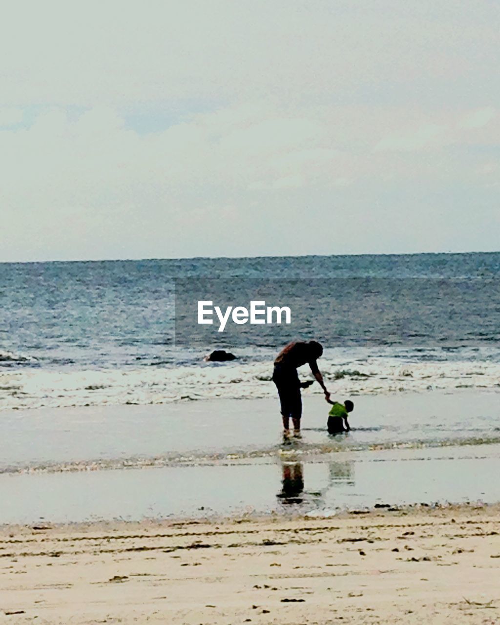 WOMAN STANDING ON BEACH