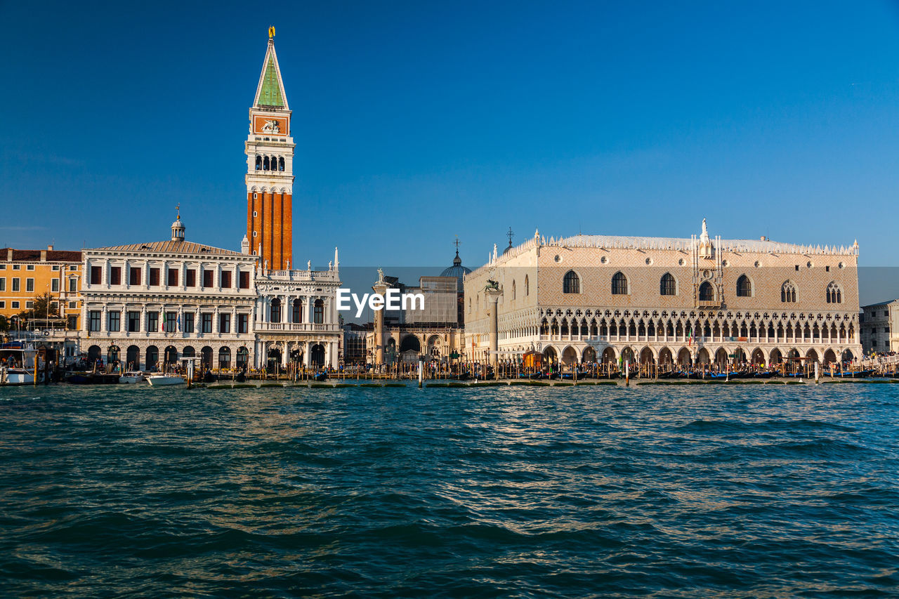 St marks square by grand canal against clear blue sky in city