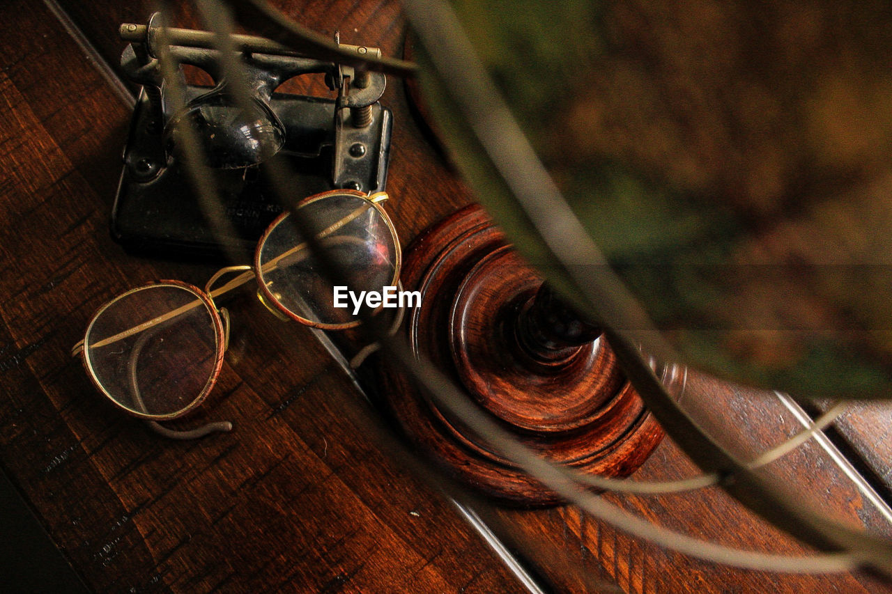 Close-up of eyeglasses with hole punch and globe on table