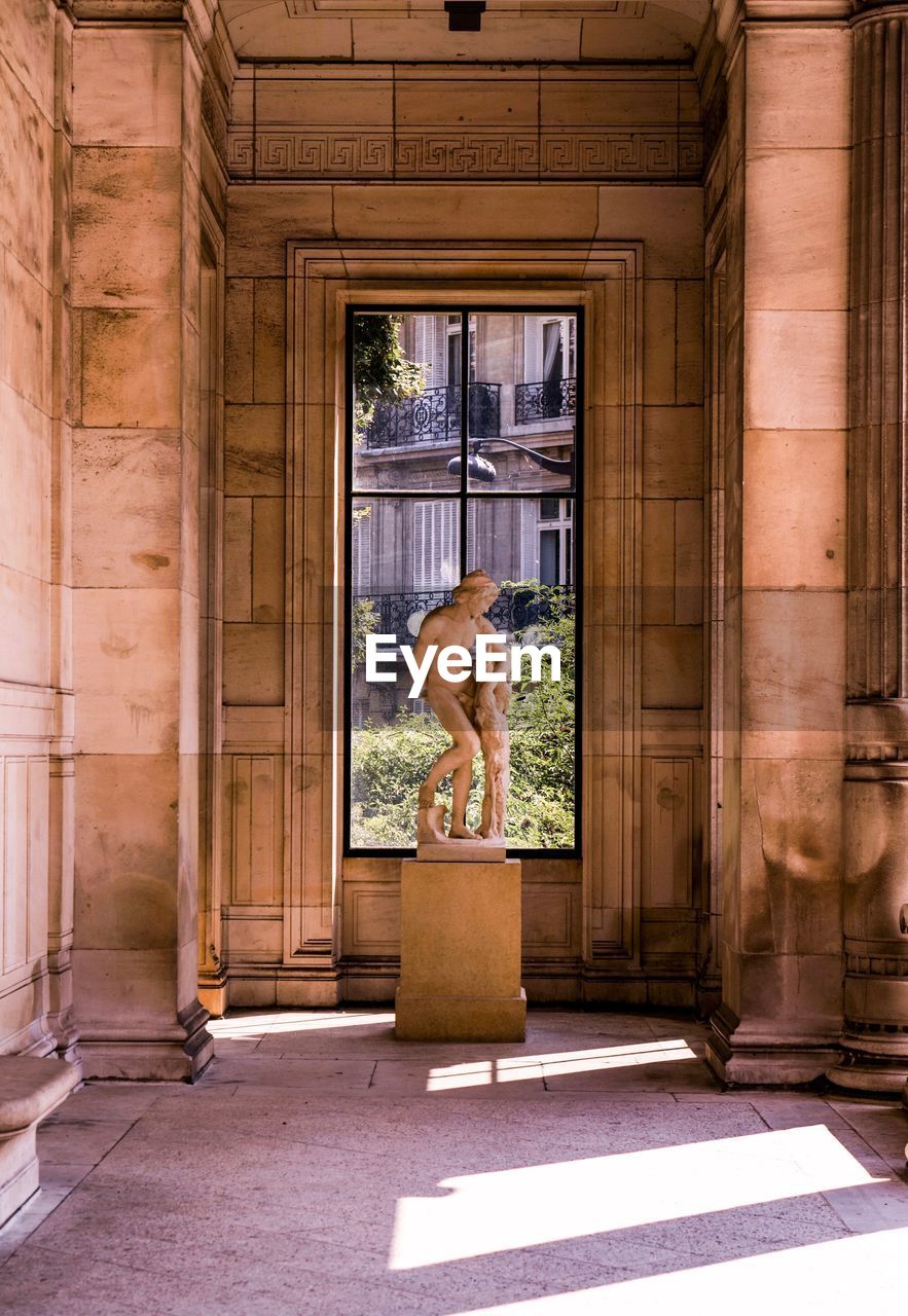 WOMAN STANDING IN FRONT OF ENTRANCE