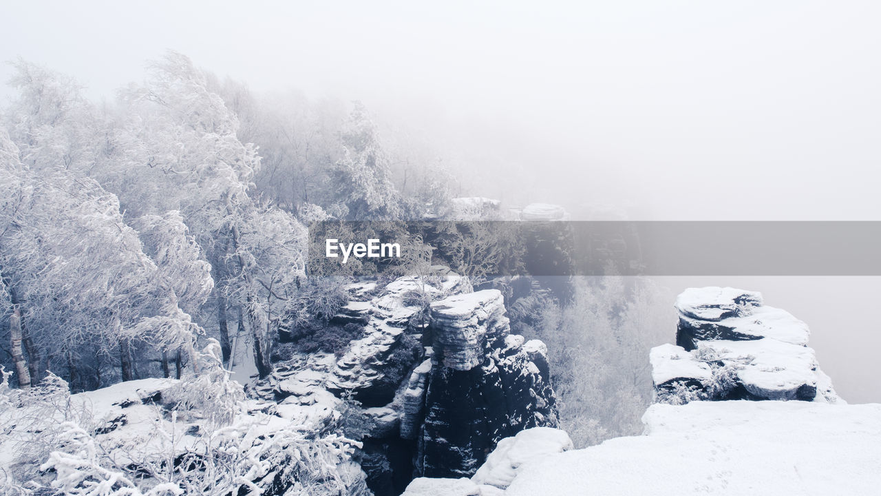 Scenic view of frozen mountains against sky