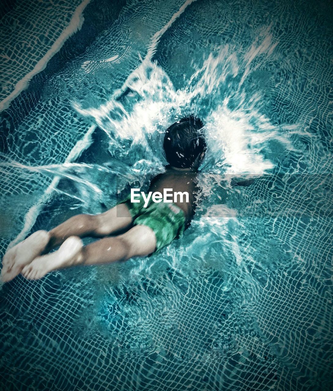 High angle view of boy diving into swimming pool