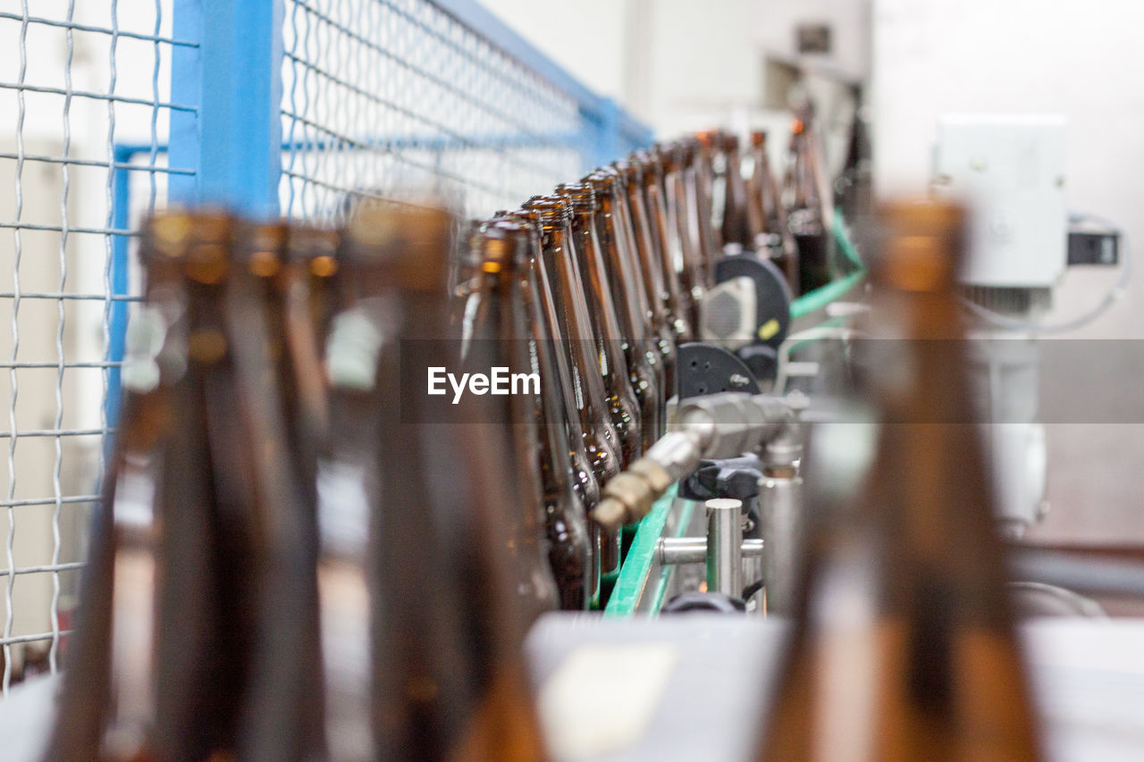 Close-up of bottles on conveyor belt in factory