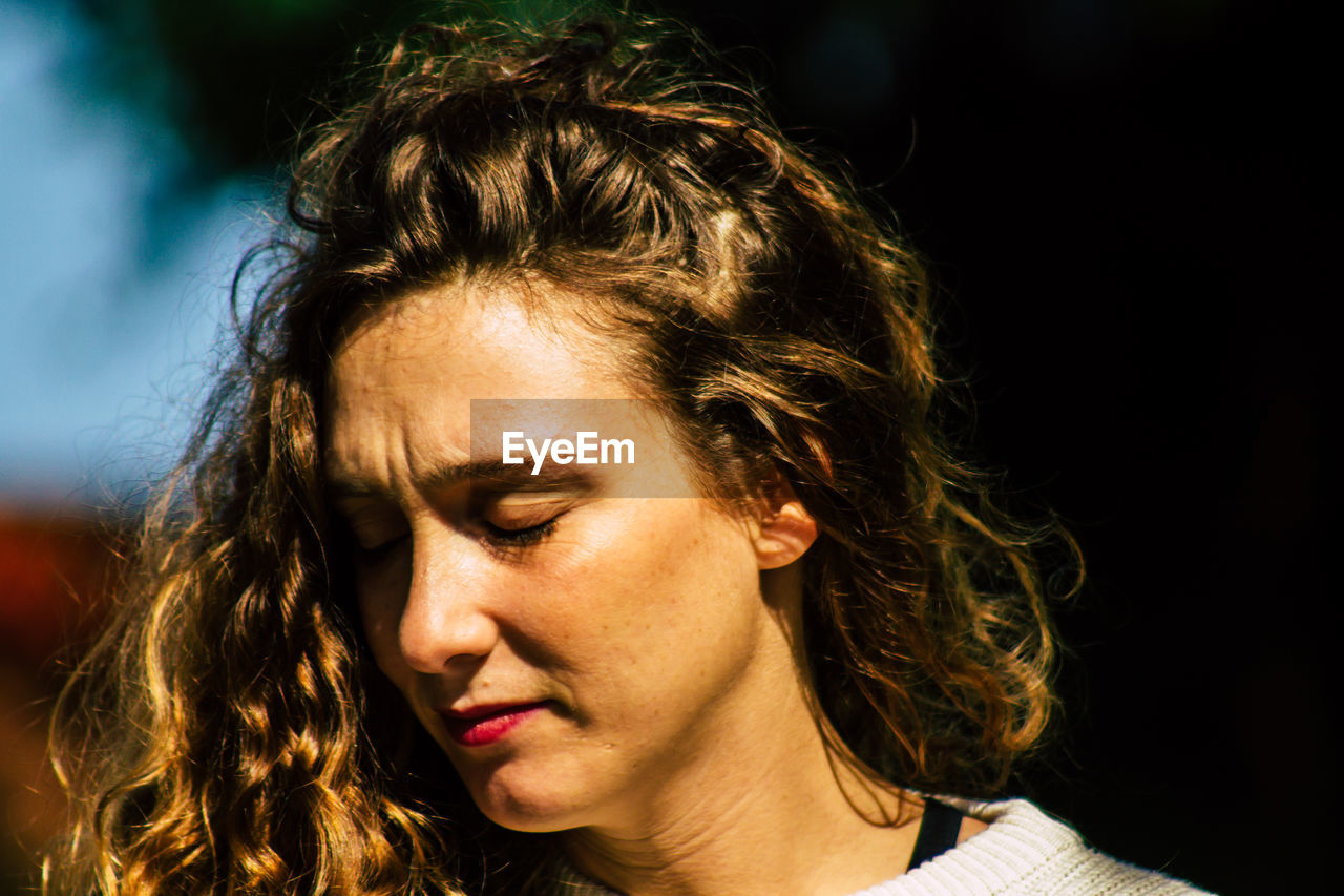 PORTRAIT OF YOUNG WOMAN LOOKING AWAY