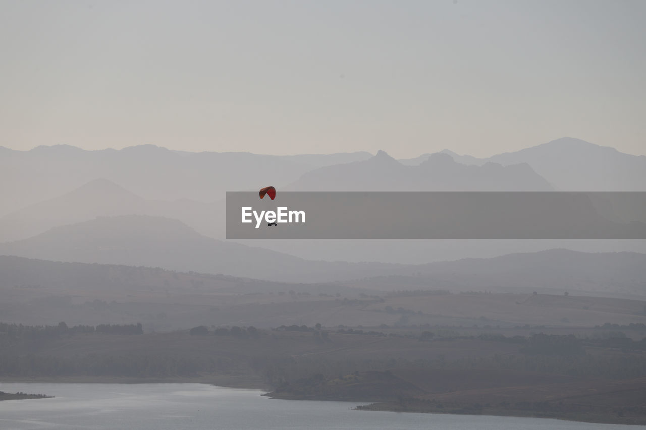 In the early morning mist, a microlight hovers over the bornos reservoir.