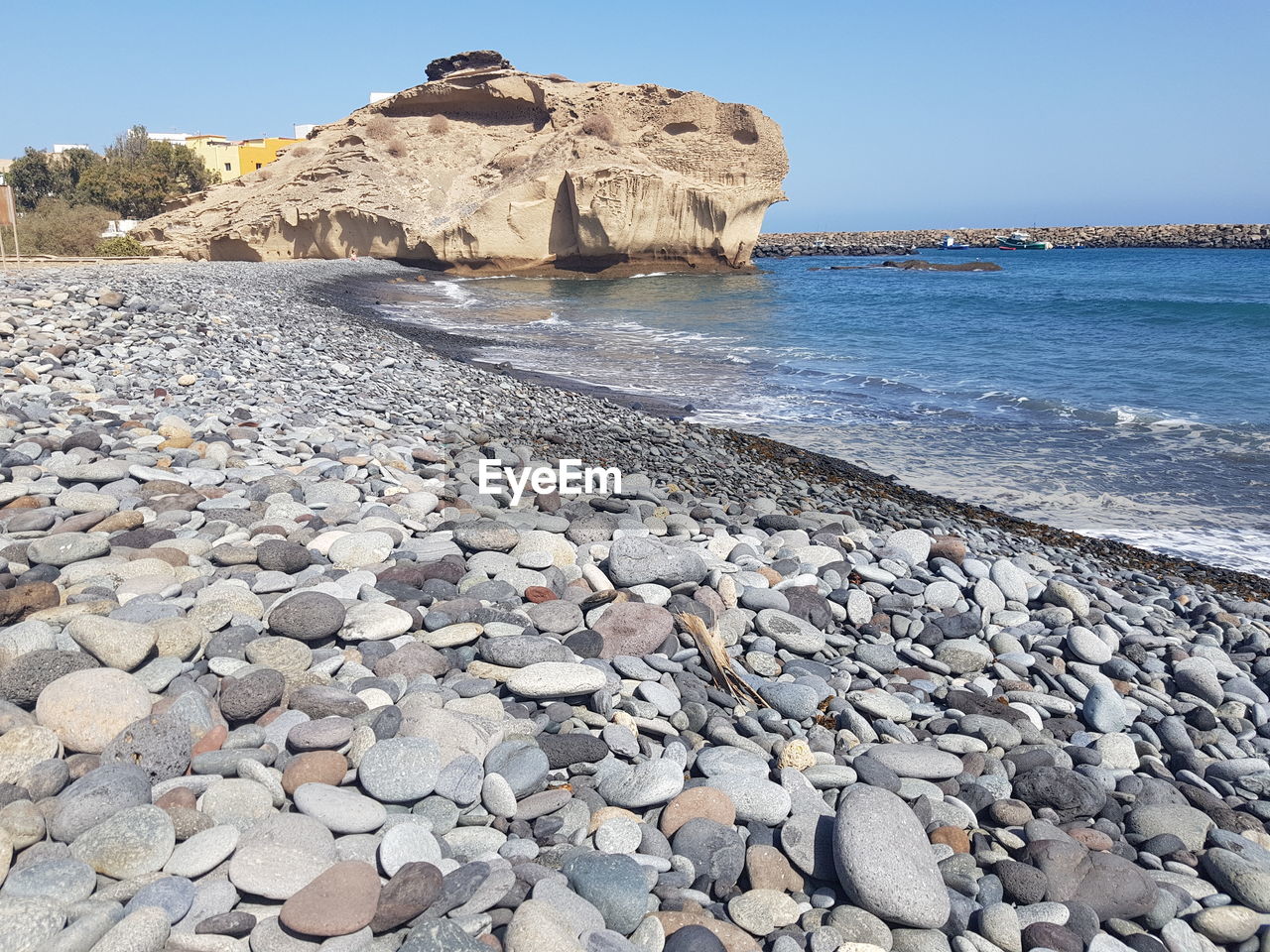 Rocks on beach against clear sky