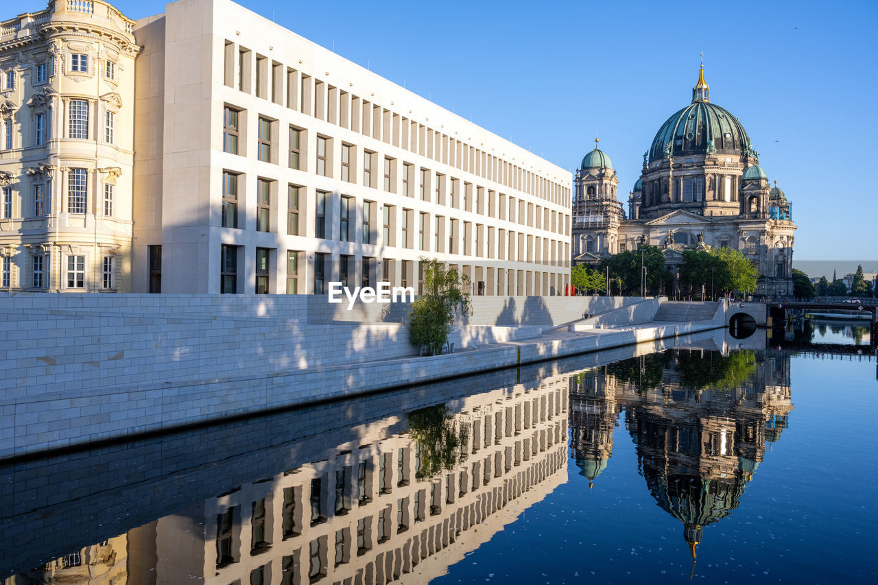 The rebuilt berlin city palace with the cathedral reflected in the river spree