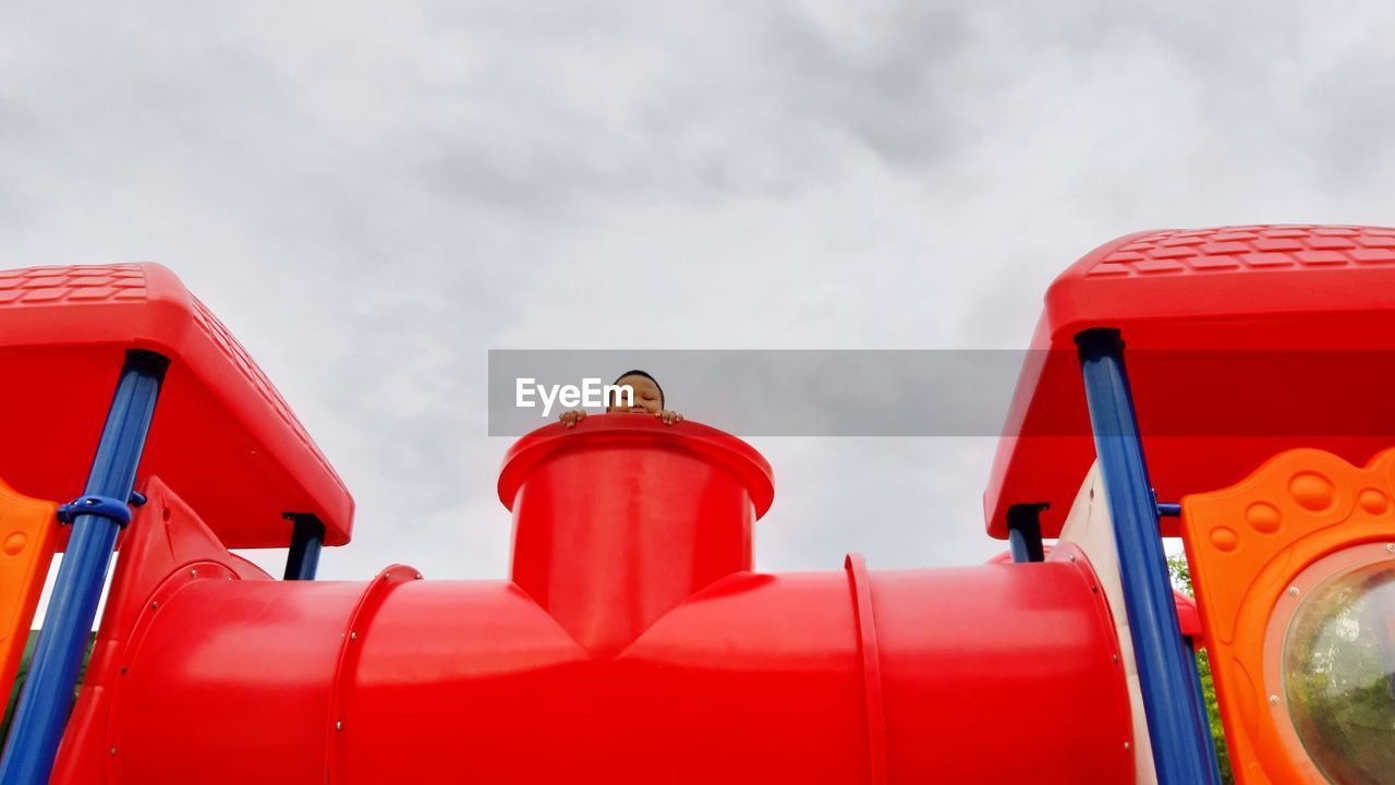 Low angle view of boy at outdoor play equipment