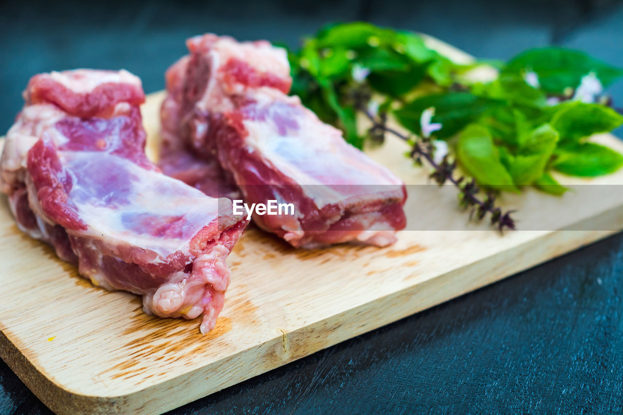 Raw meat and leaves on cutting board