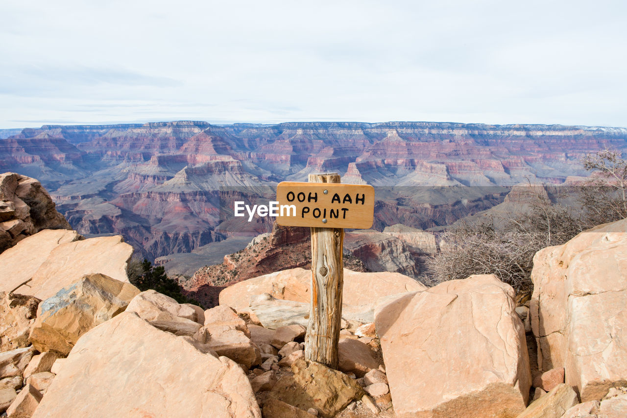 Information sign on mountain against sky