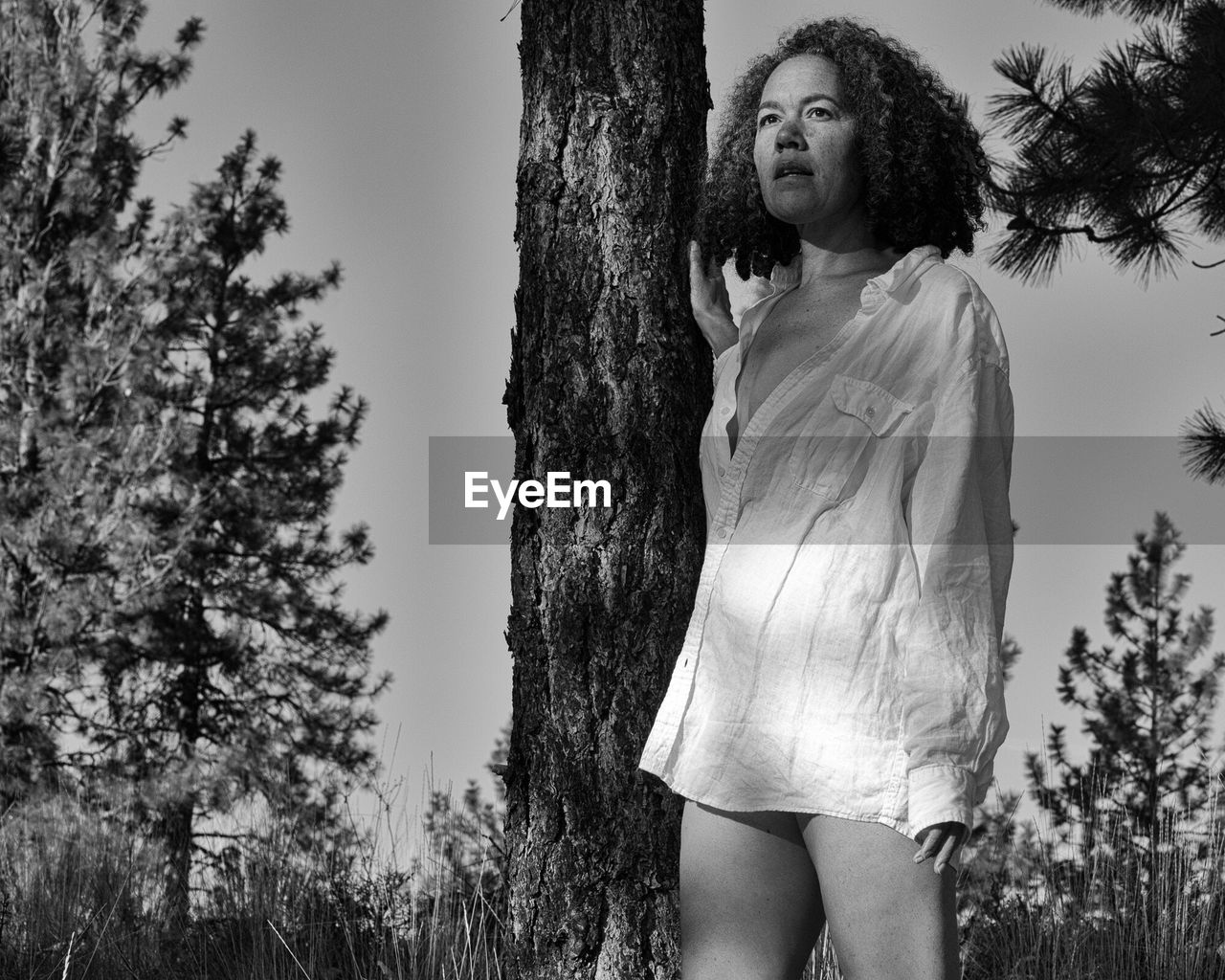 CLOSE-UP OF BEAUTIFUL YOUNG WOMAN STANDING AGAINST TREE