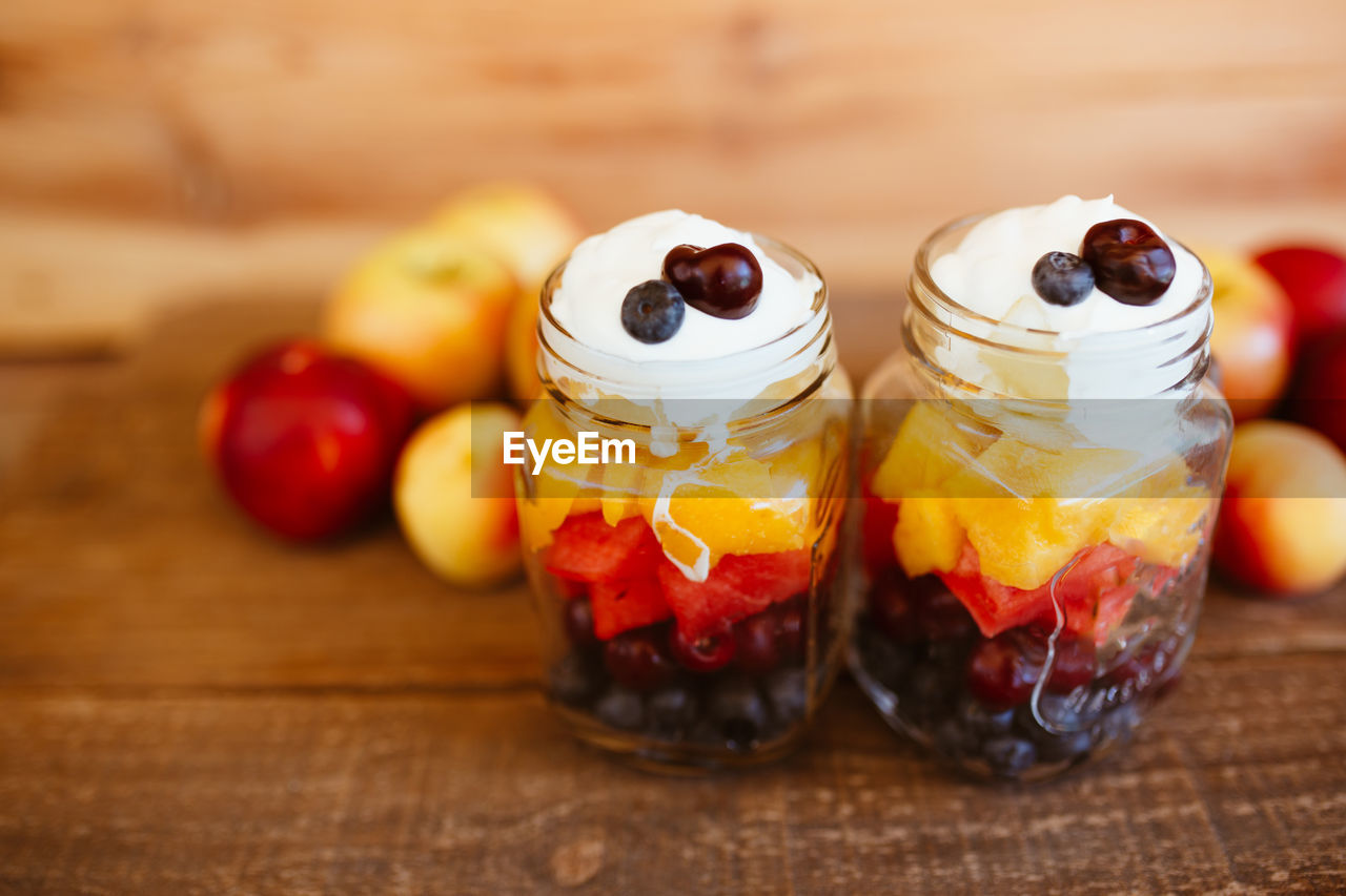Jars with chopped fruit salad. mango, apple, grapes, blueberries and strawberries, with yogurt. 