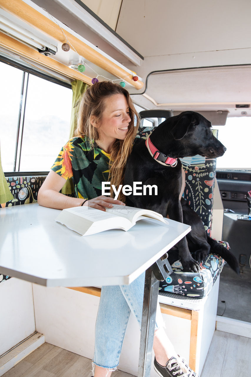 Woman traveling with dog in camper van