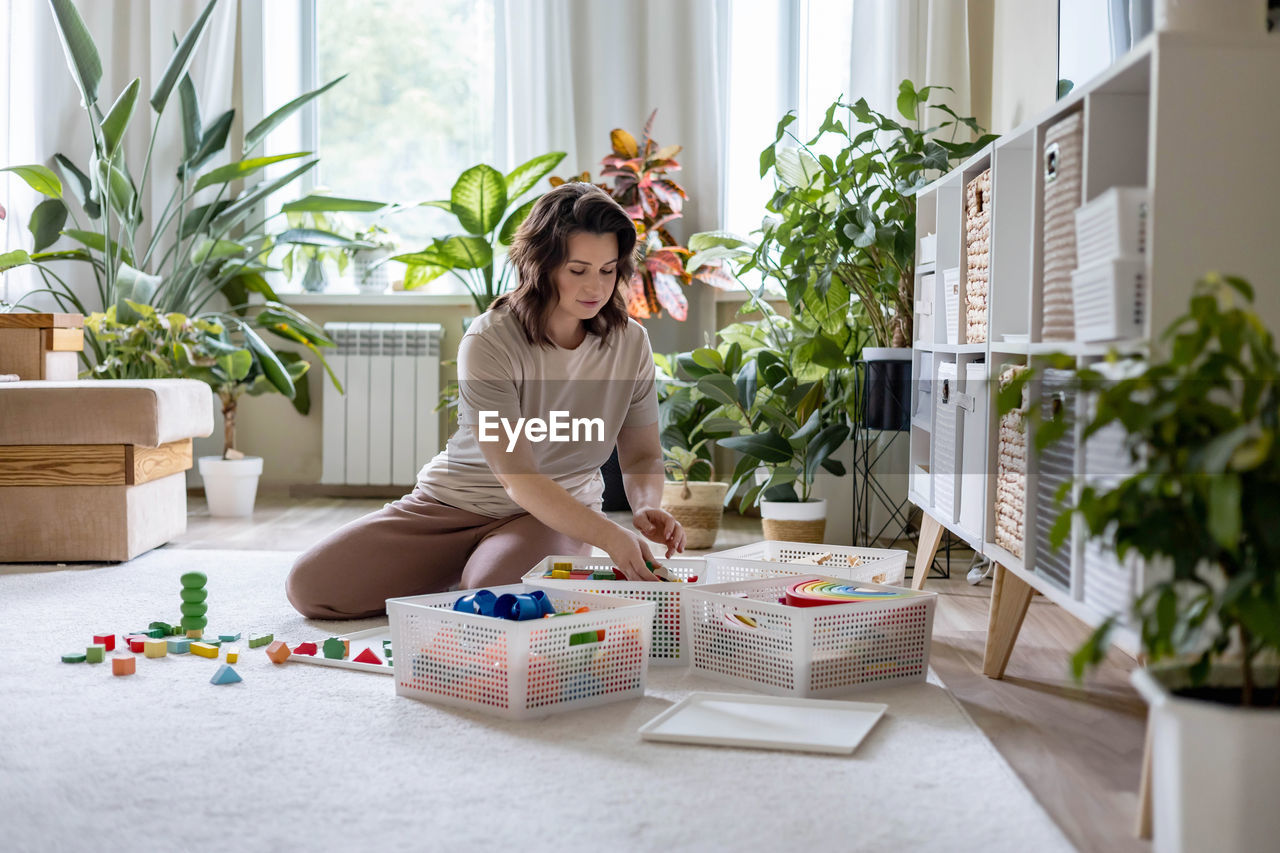 portrait of young woman using mobile phone while sitting at home