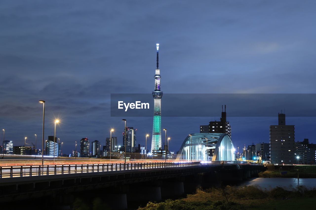 ILLUMINATED MODERN BUILDINGS IN CITY AGAINST SKY