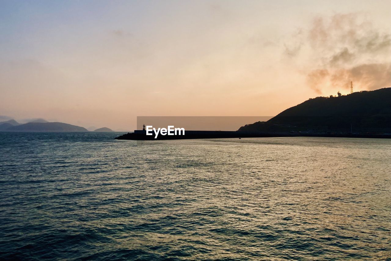 water, sky, sea, horizon, scenics - nature, beauty in nature, ocean, sunset, nature, mountain, coast, shore, dusk, environment, body of water, land, tranquility, bay, cloud, tranquil scene, travel destinations, travel, landscape, no people, seascape, outdoors, transportation, dramatic sky, evening, reflection, nautical vessel, tourism, idyllic, beach, vehicle, wave, vacation, holiday, trip, sun, sunlight, non-urban scene