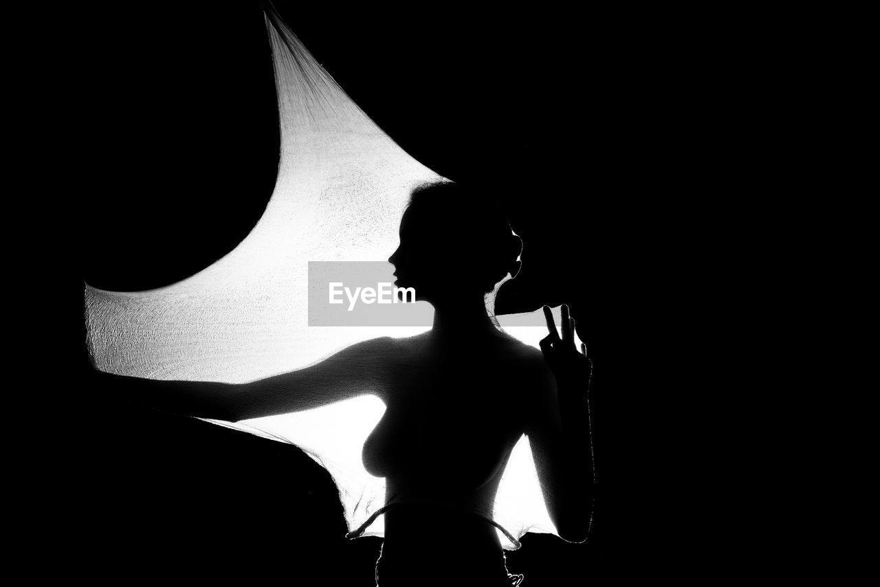 Silhouette woman standing against light