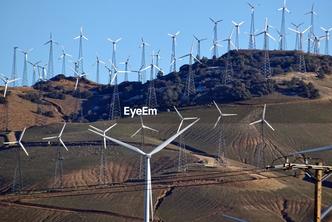 LOW ANGLE VIEW OF TRADITIONAL WINDMILL AGAINST MOUNTAIN