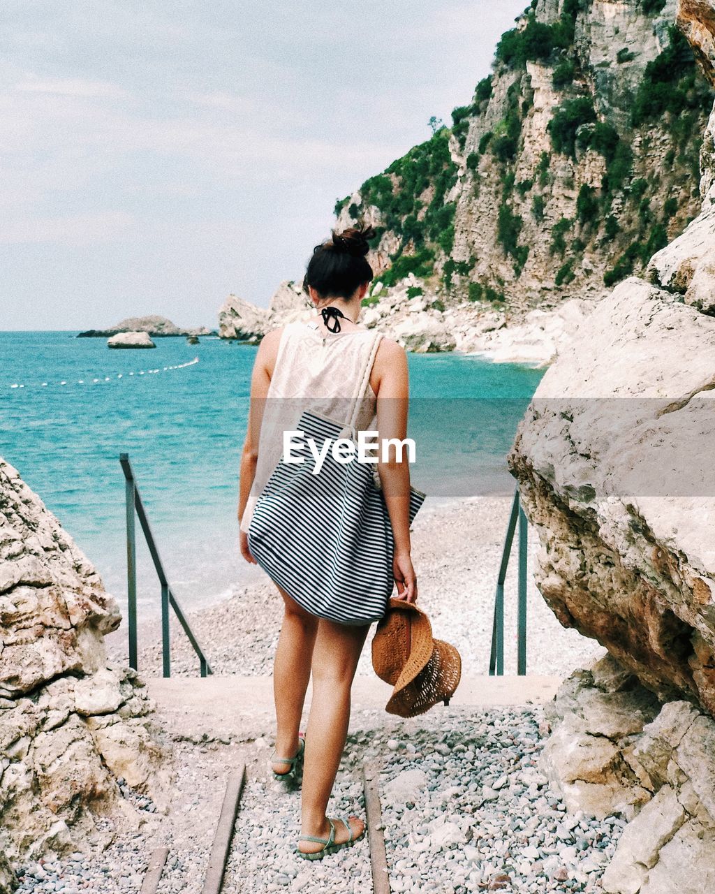 Rear view of woman walking at beach