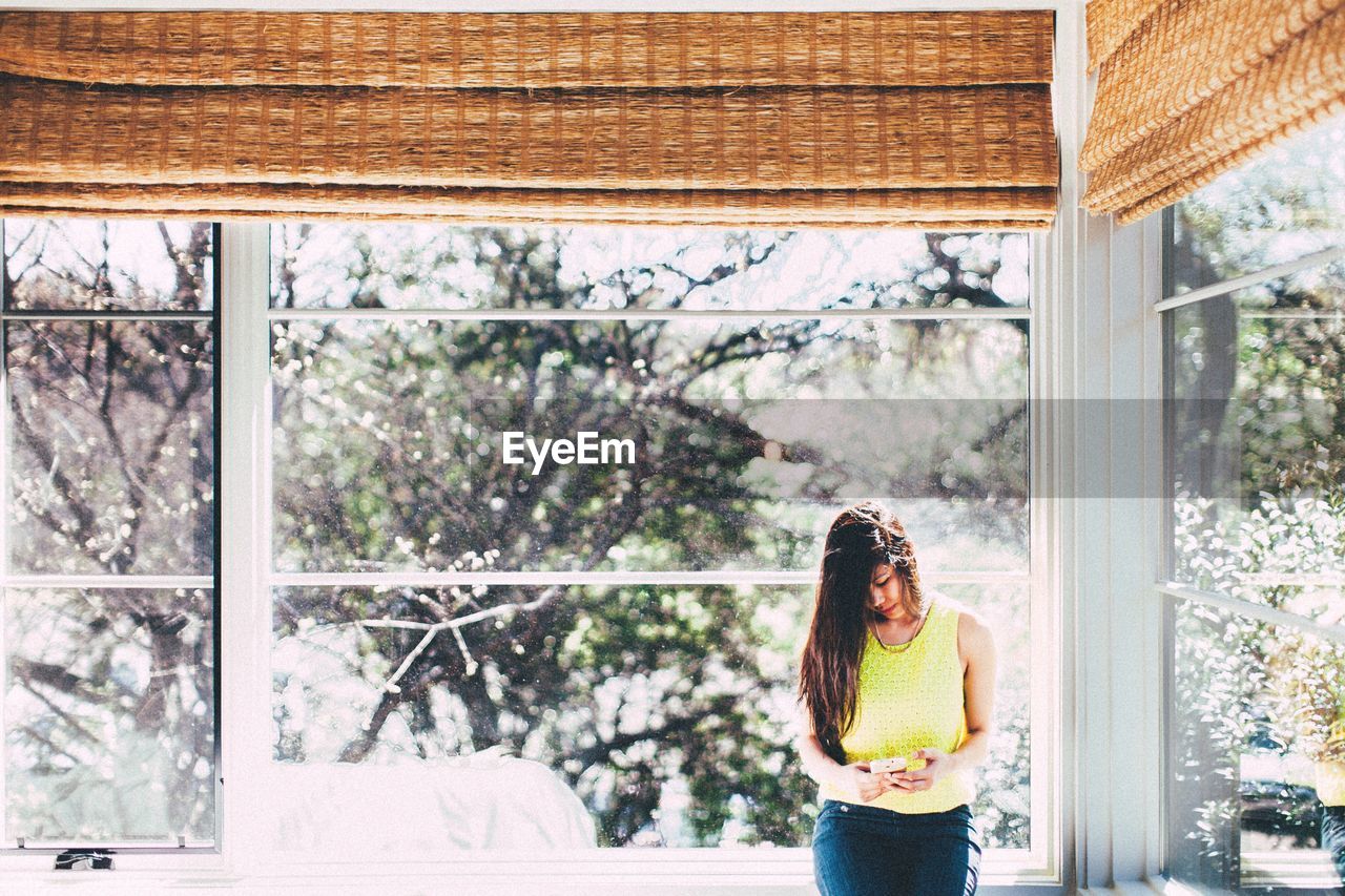 Woman standing by window