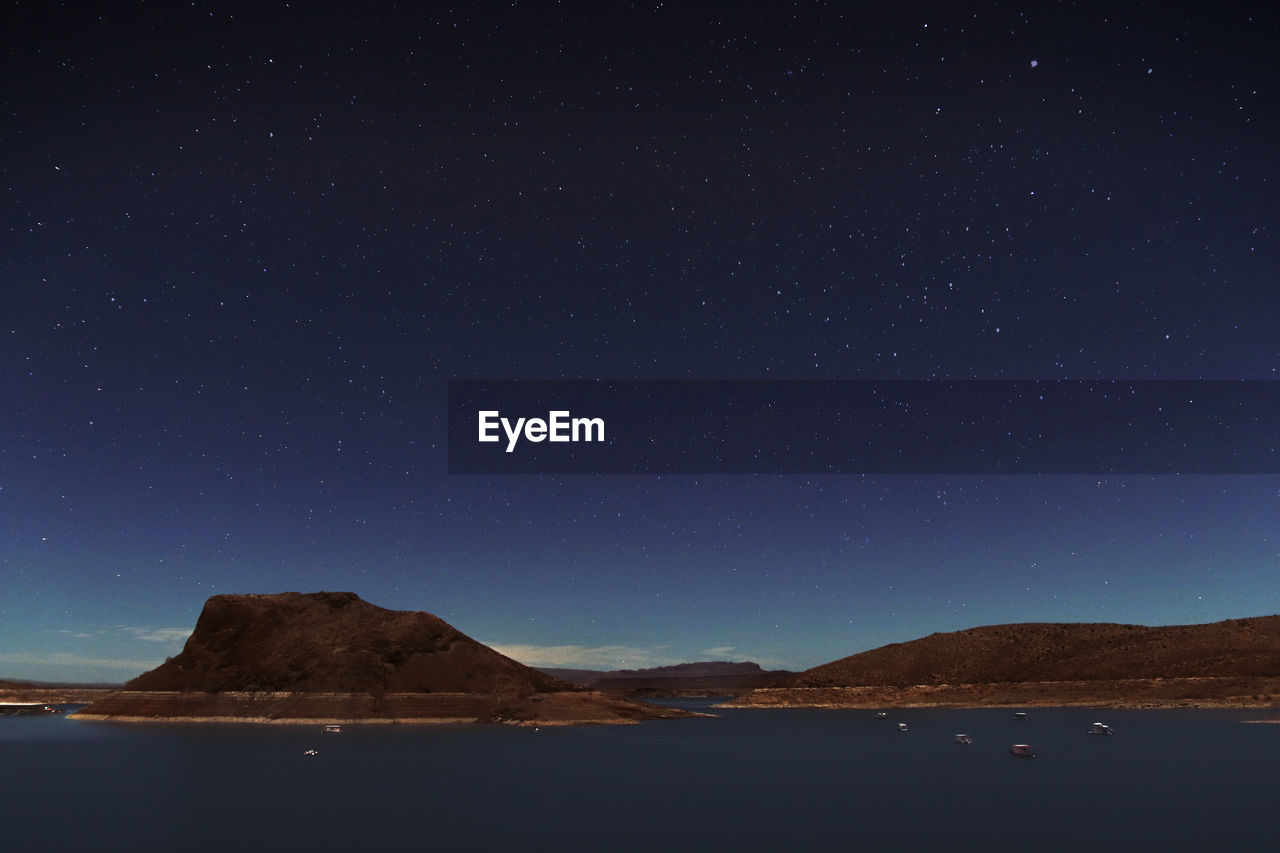 Scenic view of mountains against clear sky at night