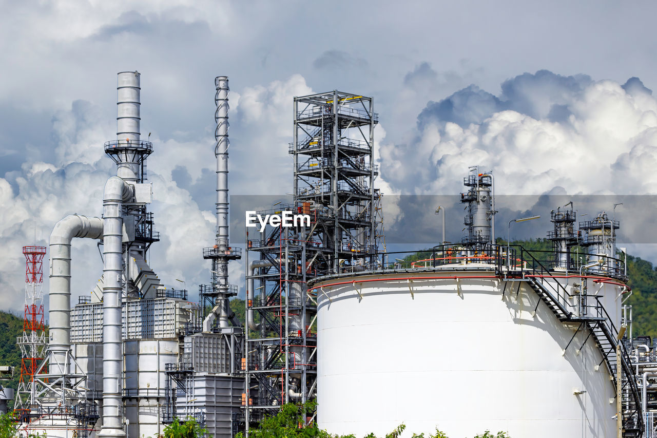 Pipelines and petrochemical industrial plant towers oil and gas refinery with blue sky cloud.