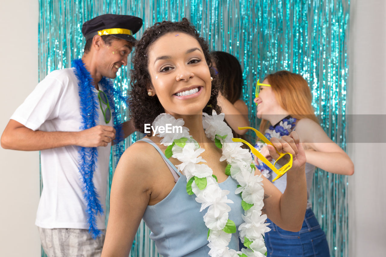 Portrait of smiling woman standing by friends during party