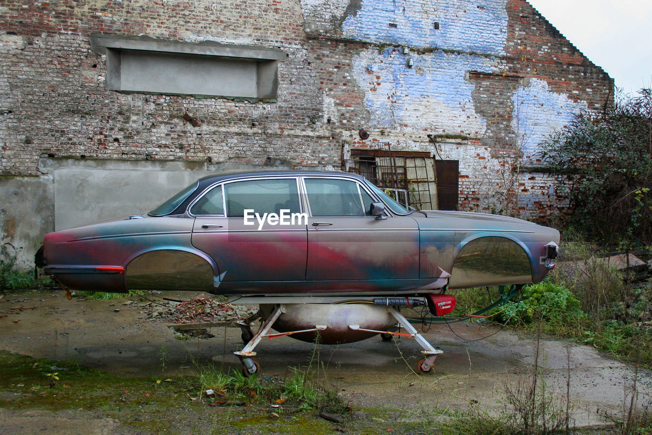 ABANDONED VINTAGE CAR ON BUILDING