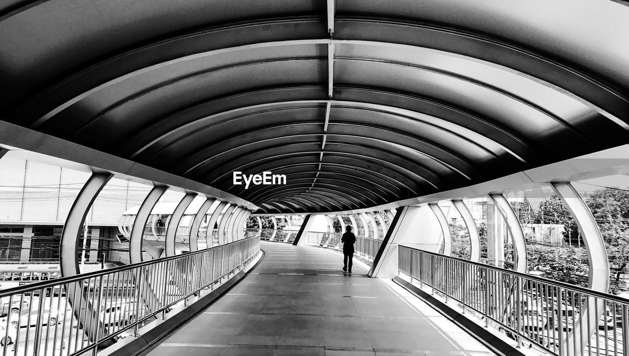 REAR VIEW OF WOMAN WALKING AT SUBWAY STATION