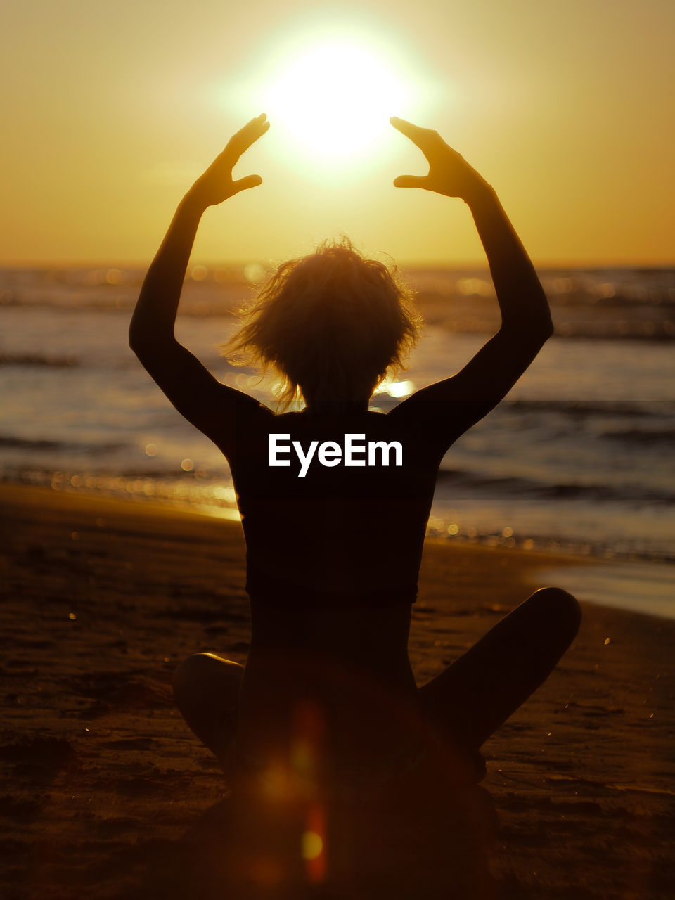 Rear view of woman at beach during sunset