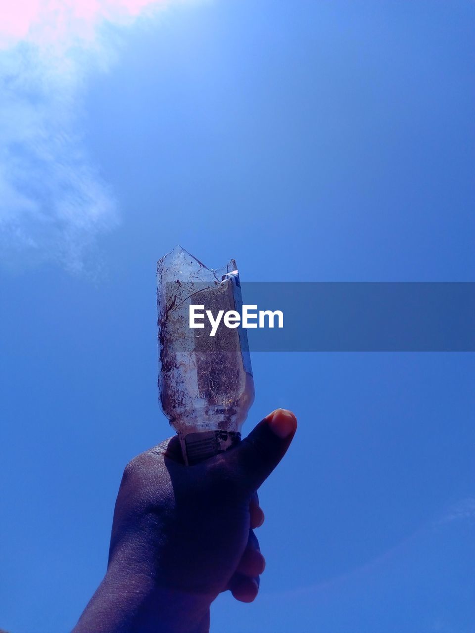 PERSON HOLDING ICE CREAM AGAINST SKY