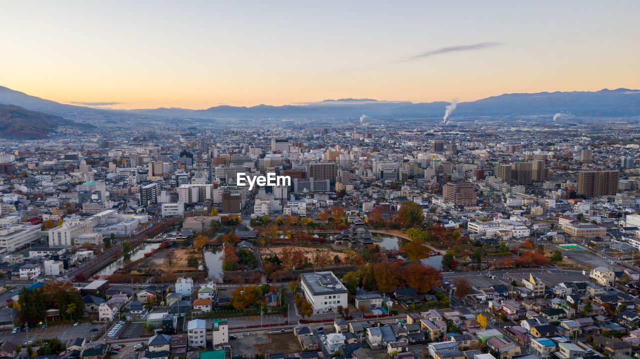 HIGH ANGLE SHOT OF TOWNSCAPE AGAINST SKY DURING SUNSET