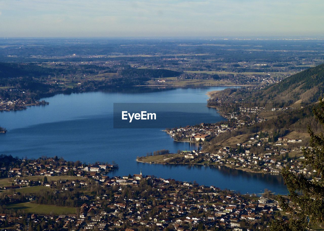 HIGH ANGLE VIEW OF CITY BY SEA AGAINST SKY